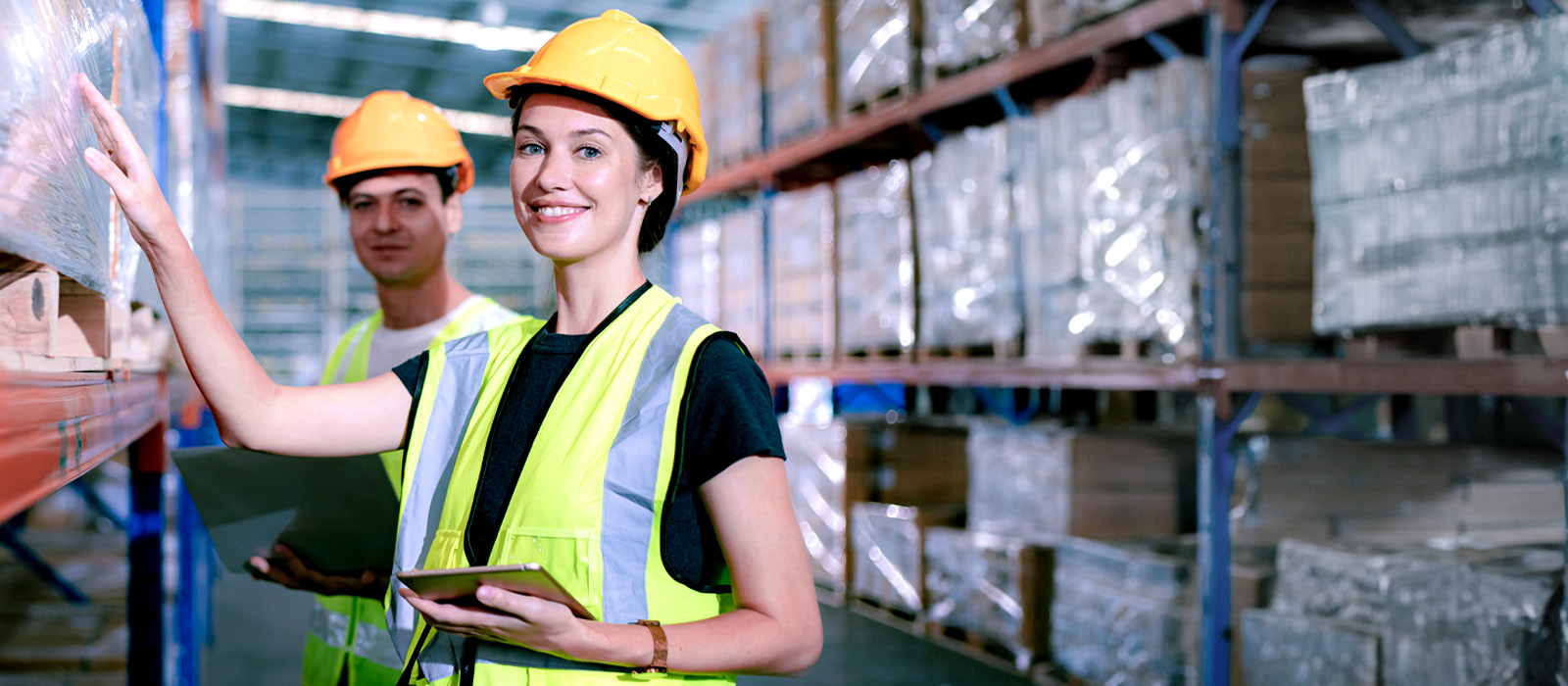 Lagerarbeiter sprechen über eine große Lagerabteilung mit Sanitärprodukten 